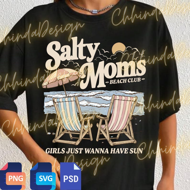 May include: Black t-shirt with a beach-themed graphic. The design features the words "Salty Moms Beach Club" above an illustration of beach chairs, an umbrella, and ocean waves. The phrase "GIRLS JUST WANNA HAVE SUN" is printed below.