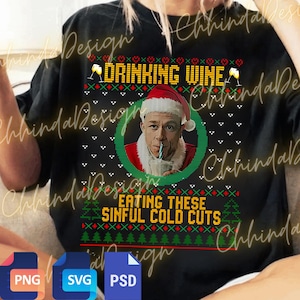 May include: Black crew neck sweatshirt with a festive design. The text "DRINKING WINE" and "EATING THESE SINFUL COLD CUTS" are displayed in a Christmas sweater style. A portrait of a man in a Santa hat is in the center.