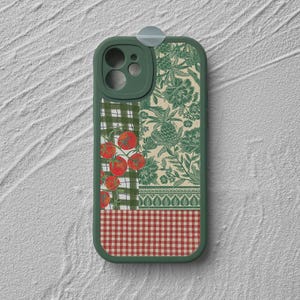 Puede incluir: Una funda de teléfono de color verde oscuro con un diseño de varios paneles. La sección superior muestra un fondo crema con motivos florales verdes, mientras que la sección central muestra tomates rojos sobre una cuadrícula verde y blanca.