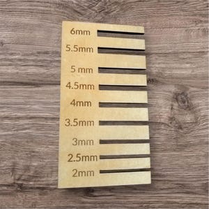 May include: A wooden ruler with markings in millimeters from 2 mm to 6 mm. The ruler is made of light brown wood and has a natural finish.