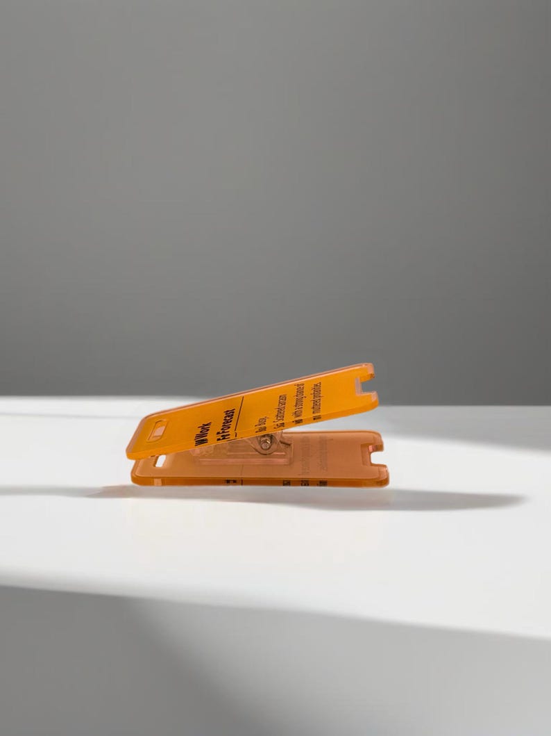 May include: Orange plastic card with the text "Work in Progress" and a small metal screw. The card is folded in half.