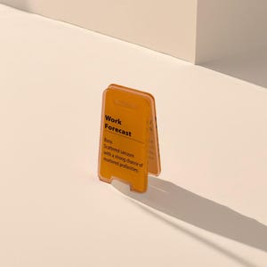 May include: A yellow plastic sign with the text "Work Forecast" and the message "Busy. Scattered sarcasm with a strong chance of muttered profanities."
