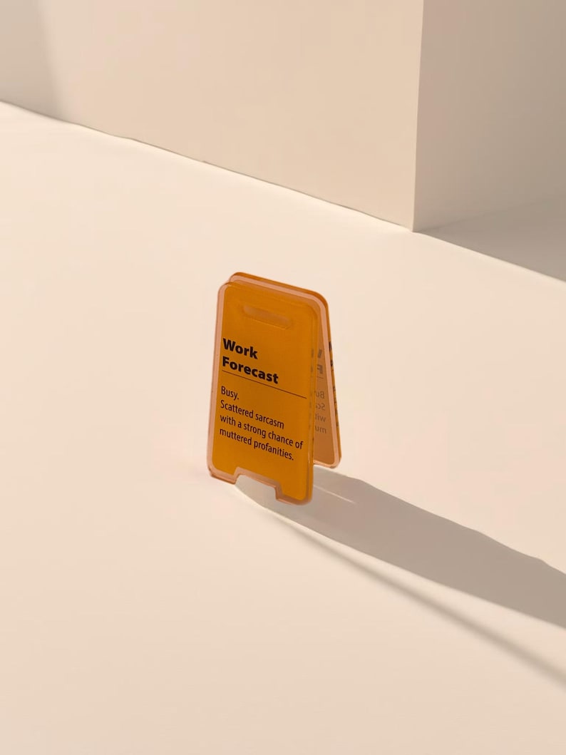 May include: A yellow plastic sign with the text "Work Forecast" and the message "Busy. Scattered sarcasm with a strong chance of muttered profanities."