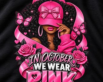 Op de afbeelding: Een zwart t-shirt met een afbeelding van een persoon met donker krullend haar die een roze baseballpet draagt met een glitterstrik en een bewustzijnslintje. Het ontwerp bevat roze rozen, vlinders en de tekst In October We Wear Pink.