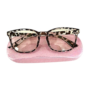 May include: A pair of brown and black tortoise shell eyeglasses with a pink leopard print case.