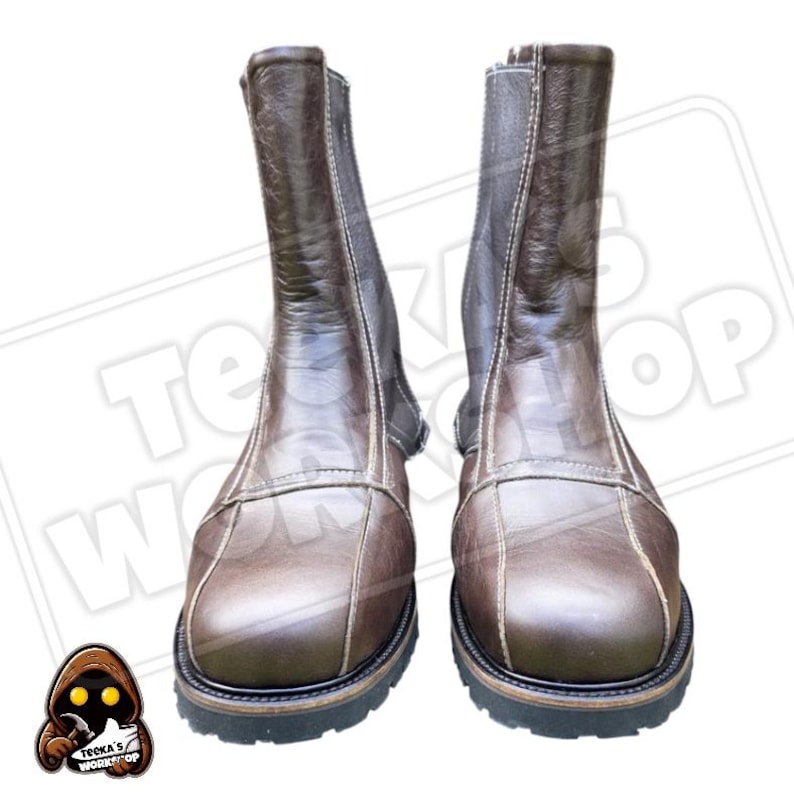 May include: A pair of brown leather boots with a zip fastening. The boots have a square toe design and a thick, black sole. The stitching is a lighter brown colour, and the boots appear to be new. The text "Teeka's Workshop" is visible in the background.