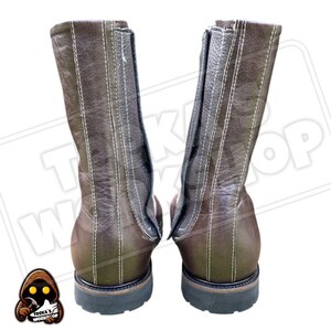 May include: A pair of brown leather boots with white stitching and a zipper closure. The boots have a rugged, workwear style with a dark sole and a mid-calf height.