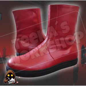 Puede incluir: Un par de botas de cuero rojo con suela negra. Las botas tienen una cremallera en el lateral y una punta puntiaguda.