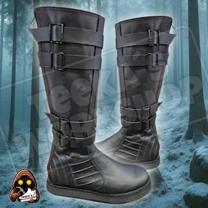 Puede incluir: Un par de botas negras hasta la rodilla con múltiples correas y hebillas. Las botas tienen suela plana y están hechas de un material liso y oscuro. El fondo presenta una escena de bosque nevado.