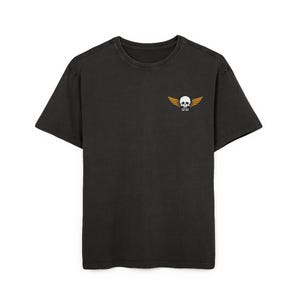 Puede incluir: Una camiseta negra de manga corta con un pequeño gráfico en la parte superior izquierda del pecho. El gráfico muestra una calavera blanca con alas naranjas a los lados y el número 99 impreso en blanco justo debajo de la calavera.