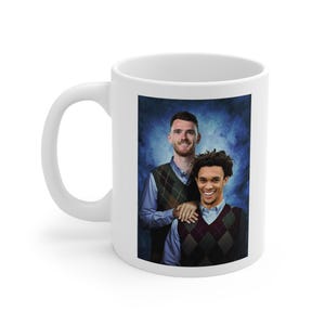 May include: White ceramic mug featuring a colourful image of two men wearing sweaters. The men are smiling and standing next to each other. The background is a blue and white gradient.