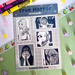 May include: A rectangular sticker sheet titled True Horror by Cuteauk featuring five black and white manga-style illustrations. The designs depict characters with spiral hair, a spiral forehead pattern, a slug, a person with hands on their face, and a scarred face. The background has a light grey grid pattern.