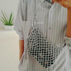 May include: A silver mesh crossbody bag with a chain strap and a large carabiner clip. The bag is rectangular with a diamond pattern. The text "kenatastudio" is visible on the clip.