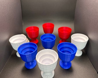 May include: A set of nine nesting cups in red, white, and blue. The cups are stacked in a pyramid shape, with the largest cup at the bottom and the smallest cup at the top.
