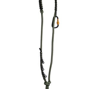 Puede incluir: Una correa para perros de paracord verde y negro con un mosquetón negro y naranja. La correa presenta un asa trenzada y un lazo en la parte inferior. Diseñada para la durabilidad y el uso en exteriores.