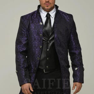 May include: A long black coat with a purple floral pattern. The coat has a high collar, a button closure, and a single breasted design. The coat is worn over a black vest and black pants.