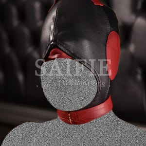May include: Black leather hood with red detailing, featuring ear pads, a handle, and a neck collar. The hood covers the entire head and face, with a circular mouth opening. The collar has a gold-coloured buckle.