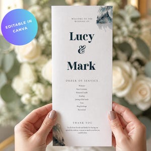 Könnte beinhalten: Eine vertikale Hochzeits-Programmkarte auf weißem Papier mit dunkelblauem Serifentext und Aquarell-Bergillustrationen. Der Text lautet Welcome to the wedding of Lucy & Mark, Order of Service und Thank You, gefolgt von einer Liste der Zeremonie.