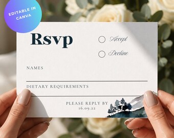 May include: A white rectangular RSVP card featuring the bold text RSVP, lines for names and dietary requirements, and two circles for Accept or Decline. The bottom right corner displays a watercolor mountain and pine tree illustration.