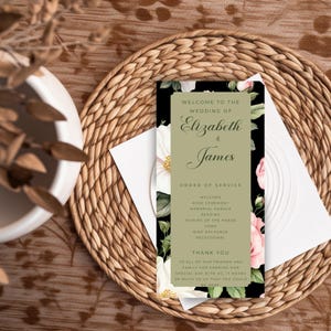 May include: A wedding program with the names "Elizabeth & James" in elegant script. The program features a black background with floral accents of white and pink roses. The order of service and a thank you message are also included.