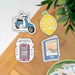 May include: A collection of four stickers with various designs. One features a blue scooter with the text "I'd rather die than survive you." Another shows a yellow lemon with the text "You turned every ordinary moment into a masterpiece."