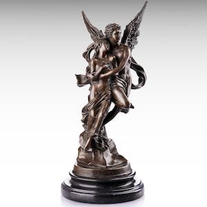 Può includere: Una scultura color bronzo che raffigura due figure in un abbraccio, una delle quali con grandi ali, su una base circolare nera. Le figure sono drappeggiate in un tessuto fluido, con la figura alata che sostiene l'altra in una posa dinamica.