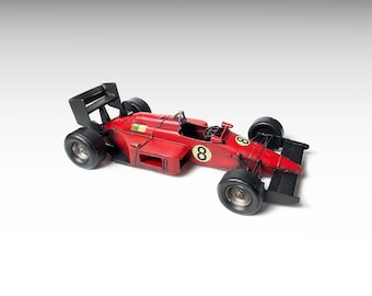 Puede incluir: Modelo de coche de carreras rojo de estilo vintage con neumáticos y detalles en negro. El número "8" se muestra en el lateral. El coche tiene un alerón y una cabina detallada.