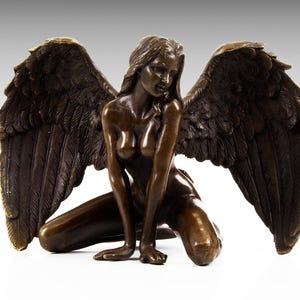 Puede incluir: Una escultura de bronce de un &aacute;ngel arrodillado con grandes alas. El &aacute;ngel est&aacute; desnudo y tiene el pelo largo. La escultura es detallada y realista.