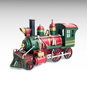 Puede incluir: Un modelo decorativo de tren de vapor en rojo, verde y dorado. El tren presenta un diseño clásico con chimenea, campana y pequeña cabina. Las ruedas son rojas y el estilo general es vintage.