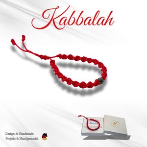 Könnte beinhalten: Rotes Kabbalah-Armband mit dunkler Perle, vor weißem Hintergrund. Das Armband besteht aus geknotetem rotem Faden. Das Wort "Kabbalah" steht in roter Schrift darüber. Eine kleine Schachtel mit dem Armband ist ebenfalls zu sehen.