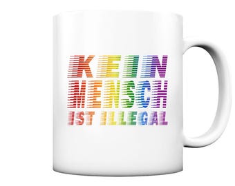 Può includere: Tazza in ceramica bianca con una grafica arcobaleno che recita "KEIN MENSCH IST ILLEGAL".