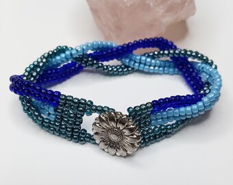Braided herringbone cuff bracelet with shades of blue seed beads and silver sunflower button closure
