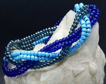 Braided herringbone cuff bracelet with shades of blue seed beads and silver sunflower button closure