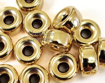 May include: A group of 15 gold-colored metal beads with a smooth, shiny finish. Each bead has a large hole in the center.