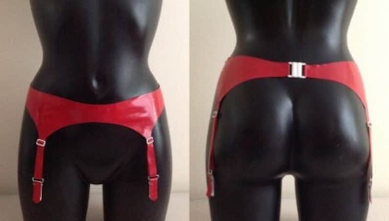 May include: Red leather garter belt with adjustable straps and silver buckles. The belt is designed to be worn around the waist and has three straps on each side that can be adjusted to fit different body types.
