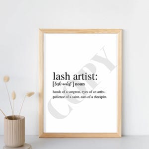 May include: A framed print with the definition of "lash artist" as a noun. The definition reads: "hands of a surgeon, eyes of an artist, patience of a saint, ears of a therapist."