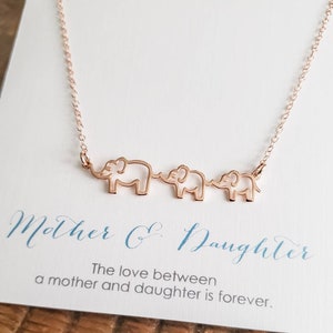 Puede incluir: Collar de oro rosa con tres siluetas de elefantes conectadas. El collar viene con una tarjeta que dice "Madre e Hija. El amor entre una madre y una hija es para siempre."