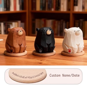 May include: Three wooden bear figurines in brown, black, and white, each sitting on a small wooden base. The bears have carved details and a cute, cartoonish appearance. The text "Custom Name/Date" is visible.