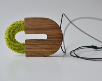 Pendentif en bois avec partie perle en vert jaune