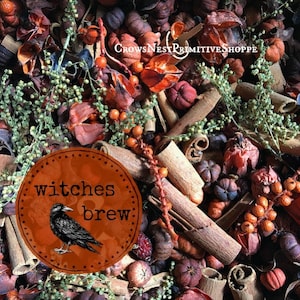 May include: A fall-themed arrangement featuring cinnamon sticks, small pumpkins, and dried botanicals in shades of orange, brown, and green. A circular label with the text "witches brew" and a crow illustration is in the foreground.