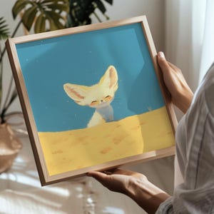 May include: A framed illustration of a cute, white fennec fox with large ears sitting in a sandy desert landscape. The background is a light blue with white speckles.