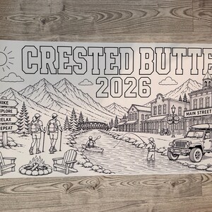 May include: A black and white coloring poster featuring the text CRESTED BUTTE 2026. The illustration depicts a mountain landscape with a town, a river with a person kayaking and fishing, two hikers, a campfire, two chairs, and a parked SUV.