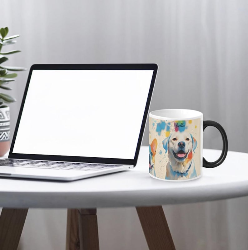 May include: White ceramic coffee mug with a black handle. The mug features a colourful watercolour illustration of a Labrador Retriever dog with the word "bella" printed on the mug.