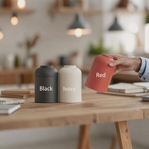 以下が含まれることがあります： 黒、アイボリー、赤の3つの円筒形の容器。黒とアイボリーの容器は直立しており、赤い容器は斜めに持たれています。各容器にはリブ付きのトップがあり、色はテキストでラベル付けされています。