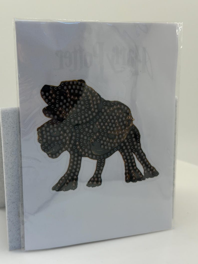 May include: A card featuring a dark brown illustration of a dog, possibly a Bloodhound, with a pattern of letters. The card is sealed in clear plastic. The words "Harry Potter" are visible in the background.