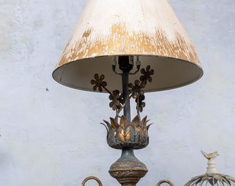 May include: A gold and blue metal table lamp with a white and gold lampshade. The lamp features a floral design with a lotus flower base.