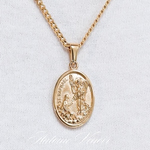 May include: Gold chain necklace with a round pendant featuring an image of the archangel Saint Michael. The pendant has the words "St. Michael" inscribed on it.