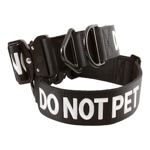 May include: Black nylon dog collar with a black metal buckle and the words "DO NOT PET" in white lettering.