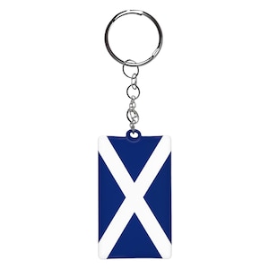 Może przedstawiać: Brelok do kluczy z niebiesko-białą flagą Szkocji i srebrnym kółkiem.