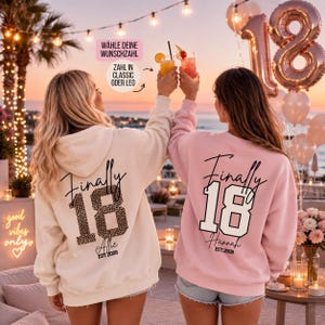 Könnte beinhalten: Ein cremefarbener Kapuzenpullover und ein hellrosa Sweatshirt, beide mit dem Schriftzug "Finally 18" auf der Rückseite. Der cremefarbene Hoodie zeigt eine "18" im Leopardenmuster und den Namen "Allie", das rosa Sweatshirt eine einfarbige "18" und "Hannah".